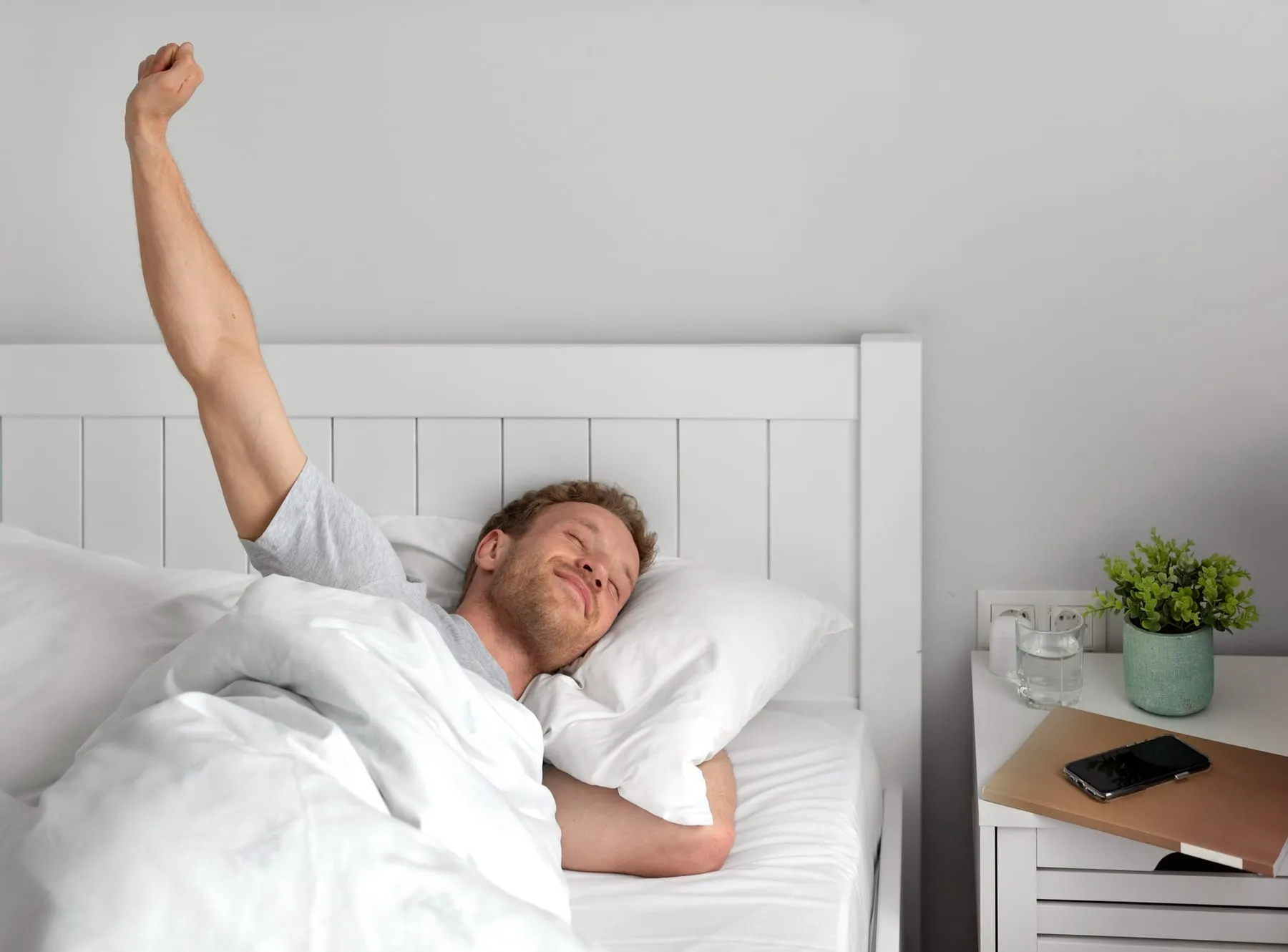 Homem se espreguiçando após uma noite de sono reparadora